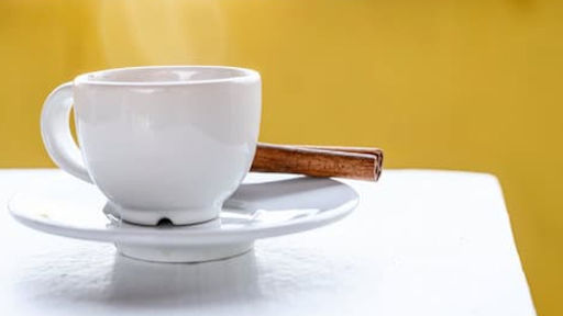 hot tea or coffee in white cup and white saucer kept on white table