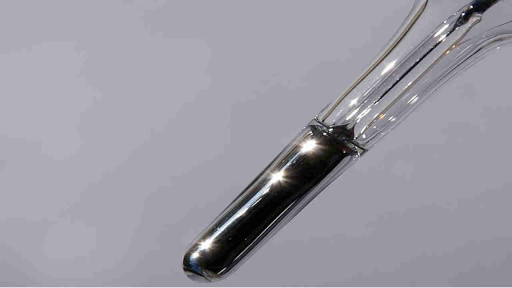tip of a thermometer in liquid in glass thermometer